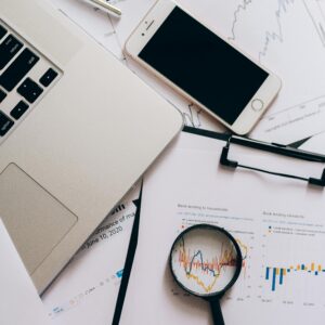 Papers with Statistics Beside a Smartphone and Magnifying Glass