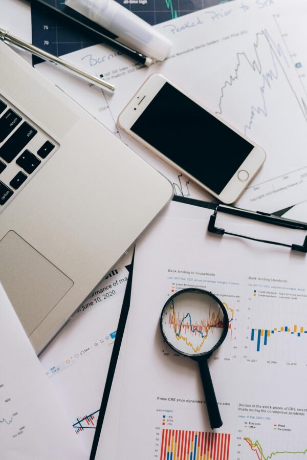 Papers with Statistics Beside a Smartphone and Magnifying Glass